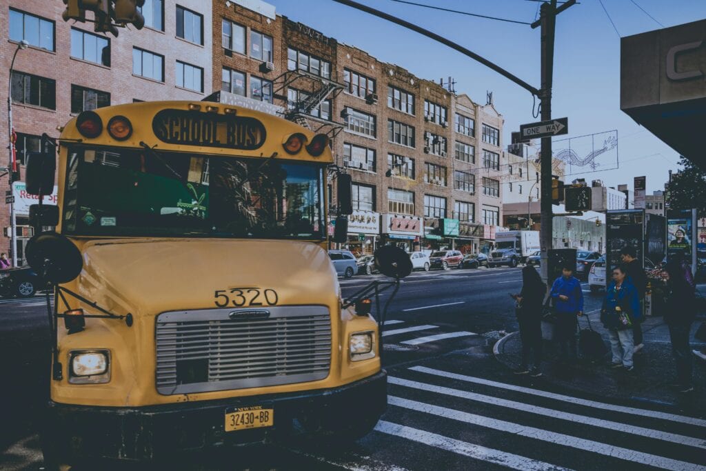 Group of students boarding a safe school trip bus rental in NYC with ZoloBus driver