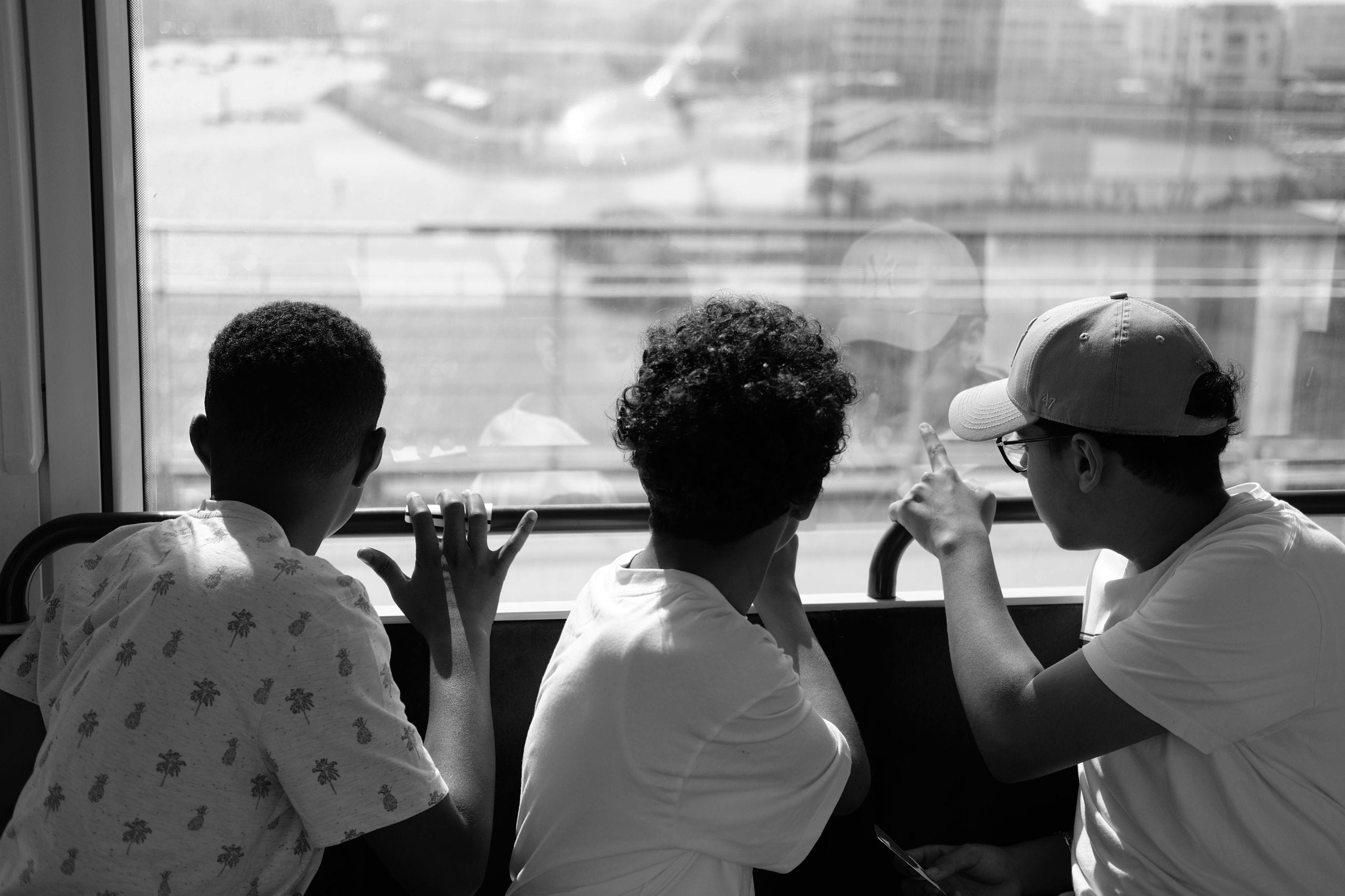 A black and white photo of three boys looking out a window in Rabat, Morocco.