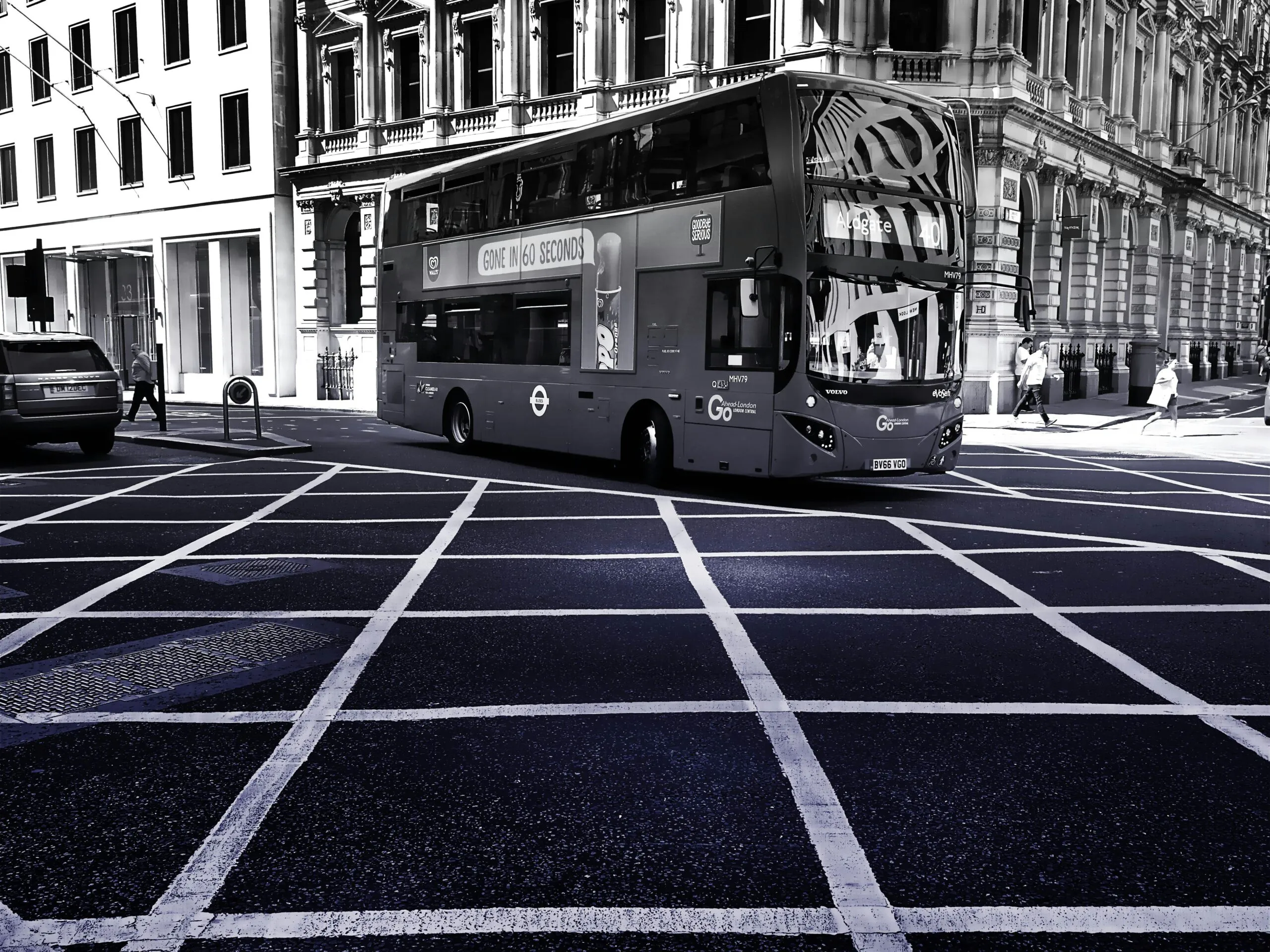 Monochrome image of a double-decker bus on London's urban streets, showcasing transportation and city life.