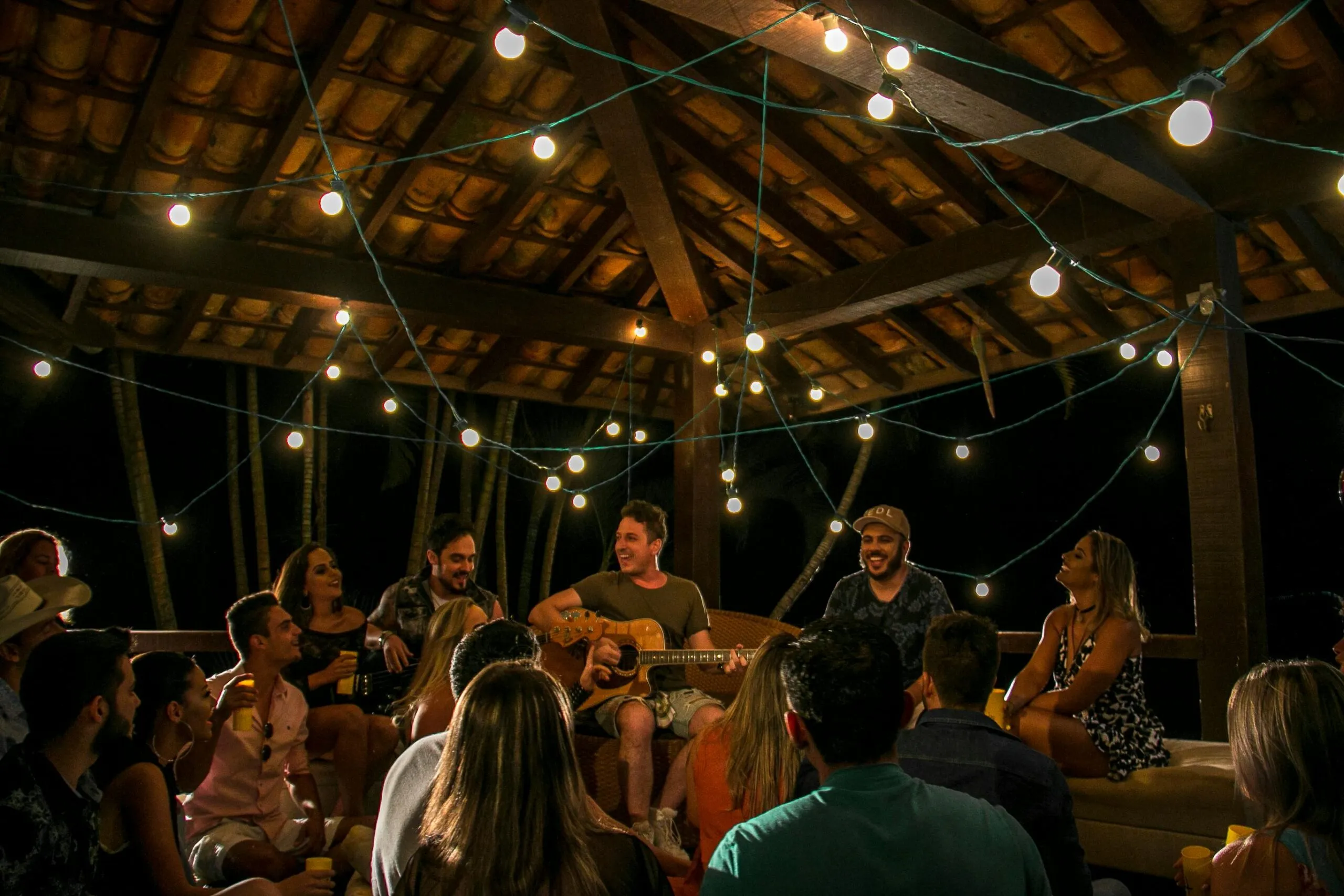 An intimate musical gathering under string lights in São Paulo, Brazil.